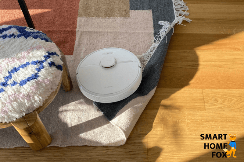 Saugroboter klappt einen sehr leichten Teppich bei der Reinigung um